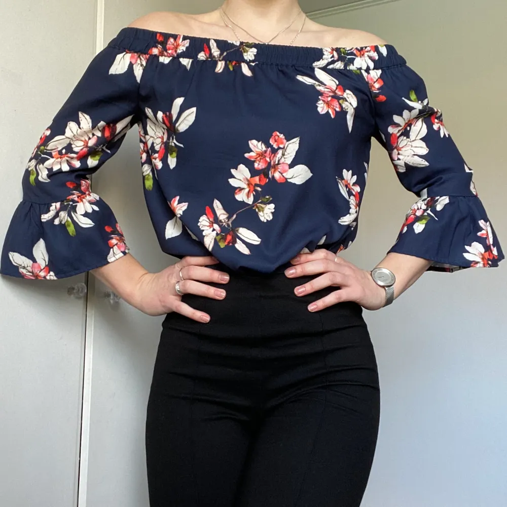 Blommig off-shoulder blus (mörkblå basfärg) från märket ONLY. Stl 36. 100% polyester. Använd ett fåtal gånger!. Blusar.