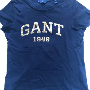 Fin marinblå t-shirt med guldtryck från Gant. I storlek XS. 