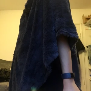 Mjuk poncho - Säljer en poncho som är väldigt sparsamt använd, det är som att ha världens mjukaste filt på sig <3 hur mjuk och len som helst, i mörkgrå glansig färg. Kan skicka/mötas upp :) det står inget märke i den, minns inte var jag har köpt! 