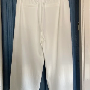 Superfräscha vita byxor! - Från H&M. Knappt använda så väldigt fint skick. Luftiga, ”fladdriga”, vida i modellen. På mig som är 165 cm slutar de vid foten. 