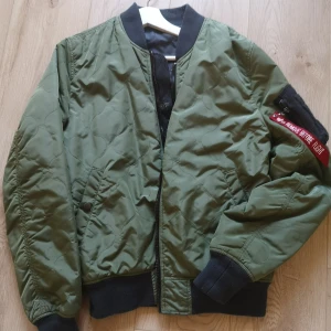 Alpha Industries bomber jacka  - Jacka från Alpha Industries. Passar M. Färg:grön. Klassiska taggen på armen. Fint skick, mkt Sparsamt använd. Kommer från djur och rökfritt hem. 