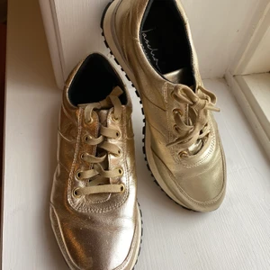 Sneakers i guld storlek 38 - Sparsamt använda sneakers i storlek 38. Skimrar i guld/silver 