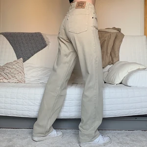 Beigea Levis Jeans - Säljer dessa coola vintage Levis Jeans. Storleken som står är W33L34 men skulle tro att de har blivit insydda. Midjemåttet är på 83cm och innerbenslängden är 83cm! Jag på bilden är 172cm och brukar ha storlek 38/W28/S-M❤️ Det näst översta knapphålet är väldigt utstretchat, skriv privat för bild på detta💓