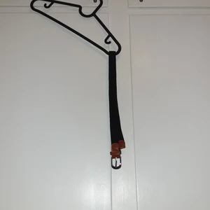 Bälte/skärp 65cm. Svart och brunt - Ett svart och brunt stretchigt bälte. 65 cm långt.