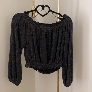 Croppad offshouldertopp - Croppad offshouldertopp, i ett svartglittrigt material. Knappt använd och i jättefint skick!! 💗✨