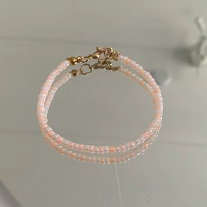 Armband färg:vit, aprikos - Ett pärlarmband jag gjort själv i färgerna vit och aprikos. Spännet är guldfärgat.  Köparen står för fraktkostnaden!💫