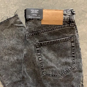 Mom jeans - Helt nya gråsvarta mom jeans som är lite fransiga nertill. Små i storleken och passar nog någon med storlek 36.