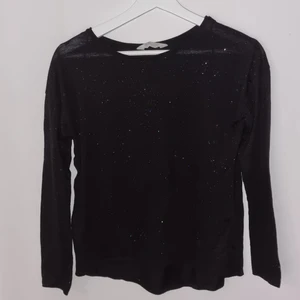 Svart långärmad tröja med glitter - Fin långärmad tröja från H&M. Den är i mycket bra skick då den inte har kommit till användning. Tröjan är svart och är i ett lite tunnare material med jättefint glitter! Storlek S.