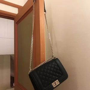 Svart väska med silverkedja  - Fin svart väska med silverkedja. Lite sliten på själva knäppet, men syns knappt🥰