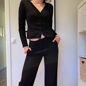 Svart skjorta strl 34 - Assnygg svart skjorta i strl 34 från NAKD, utan krage och har en djupare ringning, kommer med en extra knapp, perfekt skick. ✨GRATIS FRAKT✨