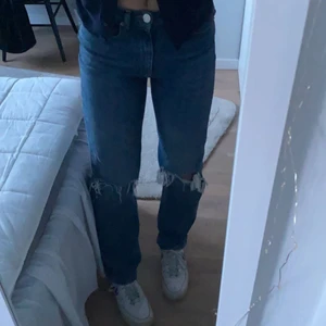 Mörkblåa jeans med hål på knäna - Mörkblåa jeans med hål på knäna i storlek 34. De är från Gina och är i bra skick! De är hyfsat högmidjade. De är på gränsen för korta på mig som är 1,72 cm så skulle säga att de sitter bra på någon som är runt 1,65 - 1,70 cm💕