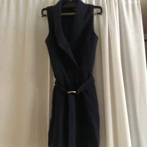 Jumpsuit  - En jätte fin jumpsuit som är mörkblå/ marinblå. Den är kort armad och korta ben. Sitter ett bälte på den så man kan dra åt i midjan. Lite v ringad fram till. Säljer den pga jag ej trivs i den