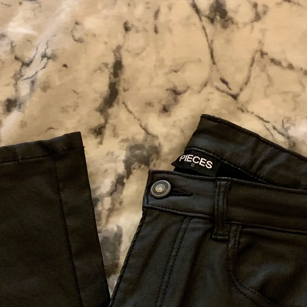 Det är ett par svarta byxor i fake skinn, otroligt stretchiga och de är aningen utsvängda. De har kanske använts vid ett tillfälle, fint skick😊 säljer för 150kr, frakten står köparen för om så önskas🚚💕 storlek M.. Jeans & Byxor.