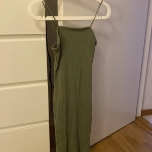 Klänning - En grön klänning som formar sig perfekt efter kroppen! Den är väldigt stretchig och man ser inte alls igenom den! Jätteskönt material och den är ca knälång. 