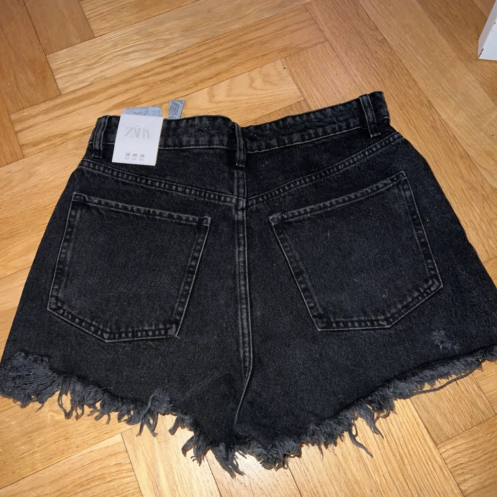 Svarta jeansshorts från Zara i storlek 38, helt oanvända. Shorts.