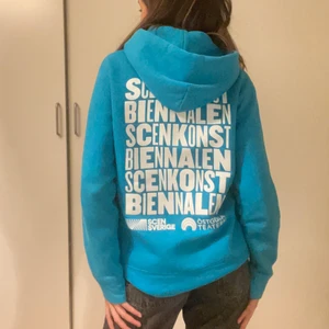 Blå hoodie - Säljer en skit cool blå hoodie som har en text på med östgöta teatern och en stor vit text på ryggen, super skön och i ett bra skick. (Köpt i en secondhandbutik) OBS! Budgivning ifall fler är intresserade men annars är den din💗