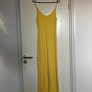 Gul klänning  - Gul långklänning från Nelly. Använd 1 gång. Super fin men kommer ej till användning. Något genomskinlig men funkar med ljusa underkläder eller som beach cover up