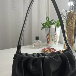 Svart axelväska  - Supersnygg väska som passar till allt!! 🤩  ▪️ Väldigt bra skick, endast använd några enstaka gånger  ▪️Köparen står för eventuell frakt ▪️Kan mötas upp i Varbergs kommun ▪️Betalning funkar bra via swish ▪️mått: 24x11x7 cm