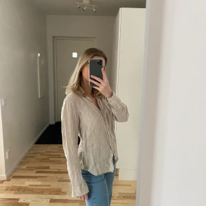 Linne skjorta från gina tricot  - En beige linneskjorta från gina tricot som är sparsamt använd.