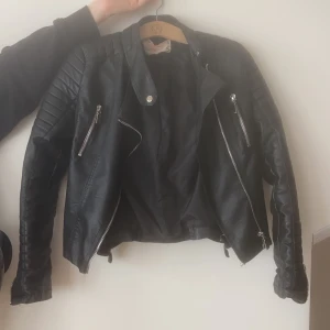 Skinnjacka - Skinnjacka från chiquelle, fin och sitter snyggt på alla dragkedjor går att öppna och stänga den är i fakeskinn. Passar 2XS till M beroende på passform.