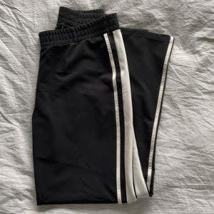 Mjukisbyxor strl L - Bekväma mjukisbyxor i strl L från Gina tricot. Har använt ca 3 gånger och inget fel på dom. Dom är vida hela vägen och har ingen dragkedja eller annan stängning. På sidorna finns två vita ränder som också går längs hela benet. Köparen står för frakt🤍