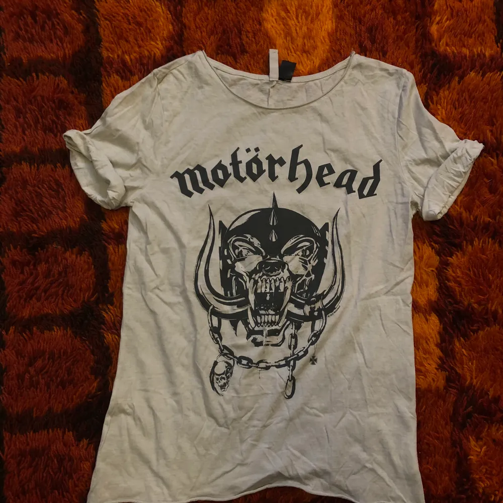 En grå/vit tshirt med Motörhead motiv. Storlek XS men är oversize så passar även S. Går att mötas upp i Hagfors eller så skickas den med posten där köparen står för frakten!. T-shirts.