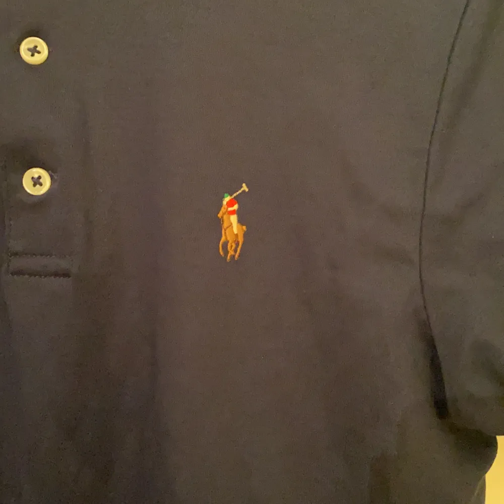 Marinblå kortärmad piké från Polo Ralph Lauren som är i nyskick, använd några gånger. Broderad logga på vänster bröst. PRIS KAN DISKUTERAS!!!. Övrigt.