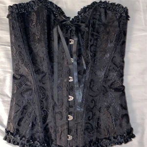 kotsett - Svart korsett med svarta detaljer i storlek xs