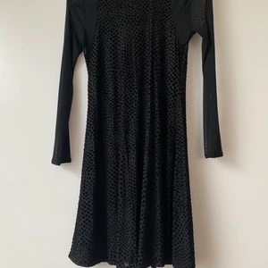 Snygg klänning från Urban Outfitters - Fin svart klänning i genomskinligt material med långa armar. Märke Cooperative, köpt på Urban Outfitters. Prickar i sammetstyg. Storlek XS. Material enligt bild. Använt ett fåtal gånger och i fint skick utan anmärkningar.