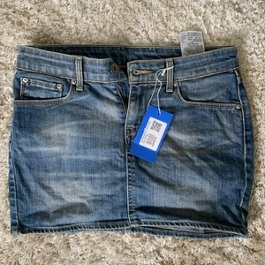 Levis minikjol i denim - Kortkort jeanskjol från Levis. Köpt på sellpy med lappar kvar, tyvärr aldrig använd av mig eftersom den var för tight. Supersöt annars! Perfekt skick