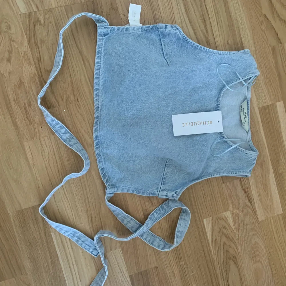 Slutsåld denim-top, croppad med öppen rygg och snörning bak. Älskar den men passar inte mig tyvärr. Var bortrest och har därför inte kunnat skicka tillbaka. Aldrig använd, endast testad! Lappen är kvar 🌸🥰😘 köpt för 349kr . Toppar.