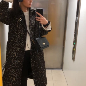 Lång höstkappa  - En höstkappa i lite lättare och svalare material. Storlek 40 och sitter lite overzised. Jag är 1.79 cm lång och kappan slutar vid mina vader ungefär. Använd några gånger. 