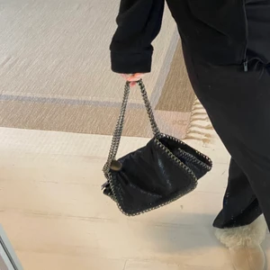 svart stella liknande väska - svart stella mccartney liknande väska! nästan aldrig använd, köpt utomlands. den rymmer jättemycket, har inga problem med att disskutera pris. frakten tillkommer. 