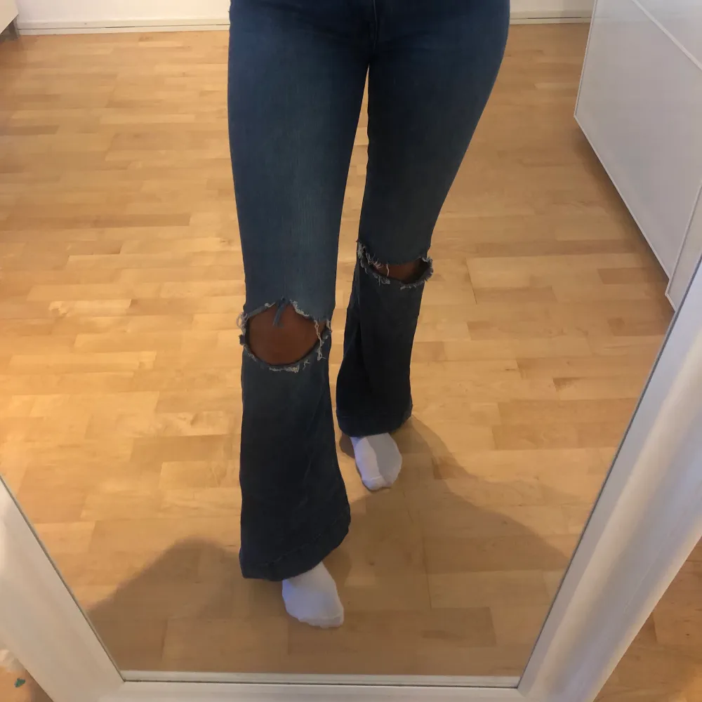 Utsvängda jeans i mörkare tvätt från Lindex med hål på knäna, knappt använda, jag är 174 för jämförelse, sitter som en smäck runt midjan och låren, skönt stretchigt material, hör av er för frågor/fler bilder💞. Jeans & Byxor.