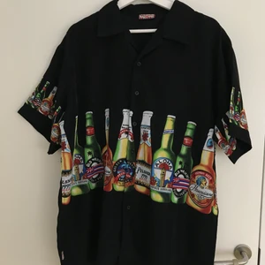 Hawaiiskjorta flaskmotiv - Size XL, fits tts  Mått: P2P - 61 cm  Längd - 76 cm  Axlar - 53 cm  