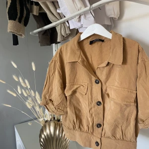 Beige topp Bershka - Beige-brun topp från Bershka i storlek S, sitter jättefint därför hyfsat använd, dock inget som syns☺️ Har knappar, fickor och krage - på bilden är tröjan ostruken⚠️ Pris kan diskuteras:)