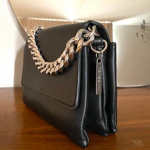 Chunky chain bag - Stilren svart PU läderväska med en skit cool silver chain som verkligen coolar till vilken outfit som helst. Köpt från Ivy revel för 800kr och använd en gång, alltså i nyskick! Axelbands rem medföljer som man kan sätta på och ha den som crossbody! Den har tre fack inuti så man får plats med både smink, telefon och lyft;)