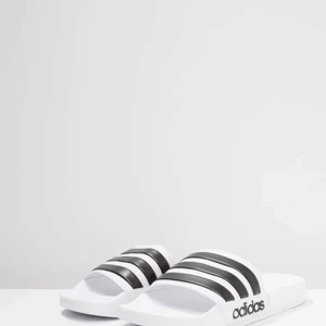 Oanvända adidastofflor - Superfina tofflor från adidas, oanvända. Säljer pga små för mig. Köparen står för frakten. Fraktar endast. Nypris 249kr.