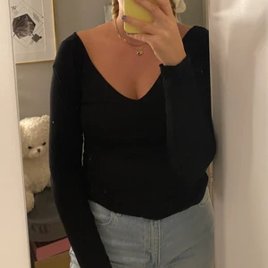 Långarmad  - En svart Långarmad tröja, som är V-ringad fram och bak. 