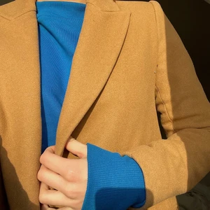 Mocka färgad kappa - Figursydd kappa i mocka färgat tyg. Slutar mitt på låret. Storlek S🕺🏼