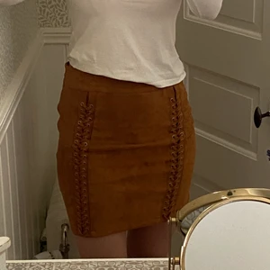 Brun mockakjol med detaljer - Säljer min fina mockakjol som tyvärr inte är min stil. Fina detaljer som ger en fin form💕 Väldigt bekväm och i nyskick! Inköpt hos Tessie i gbg. Själv är jag 75cm i midjan och 102 cm över höften och då passar den bra. Priset är exklusive frakt. Om fler är intresserade sker budgivning. Tveka inte att kontakta vid frågor. 