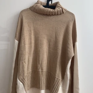 Lång stickad turtleneck  - En fin stickad turtleneck från nakd. Den är 2 färgad. Den är stor i storleken men används som oversize tröja.