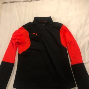 Puma träningströja i röd och svart. - Det står att det är storlek XL men den sitter ungefär som en XS/S tröja. Skönt material och inte använd mycket alls