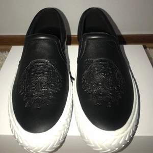 Kenzo slip on sneakers - Hej! Säljer ett par splitternya sneakers jag köpte för drygt en månad sen. Skorna är helt oanvända men säljes pga för stor storlek. De finns ute för 2838kr men säljer mina för 2600kr. Pris kan disskuteras. Kvitto finns med:) 