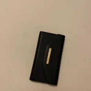 Säljer ett svart plånboksskal från Ideal of Sweden med löstagbart mobilskal i. Fungerar med Ideal of Swedens andra mobilskal också. Fint använt skick. 80kr. Köparen står för frakten:)
