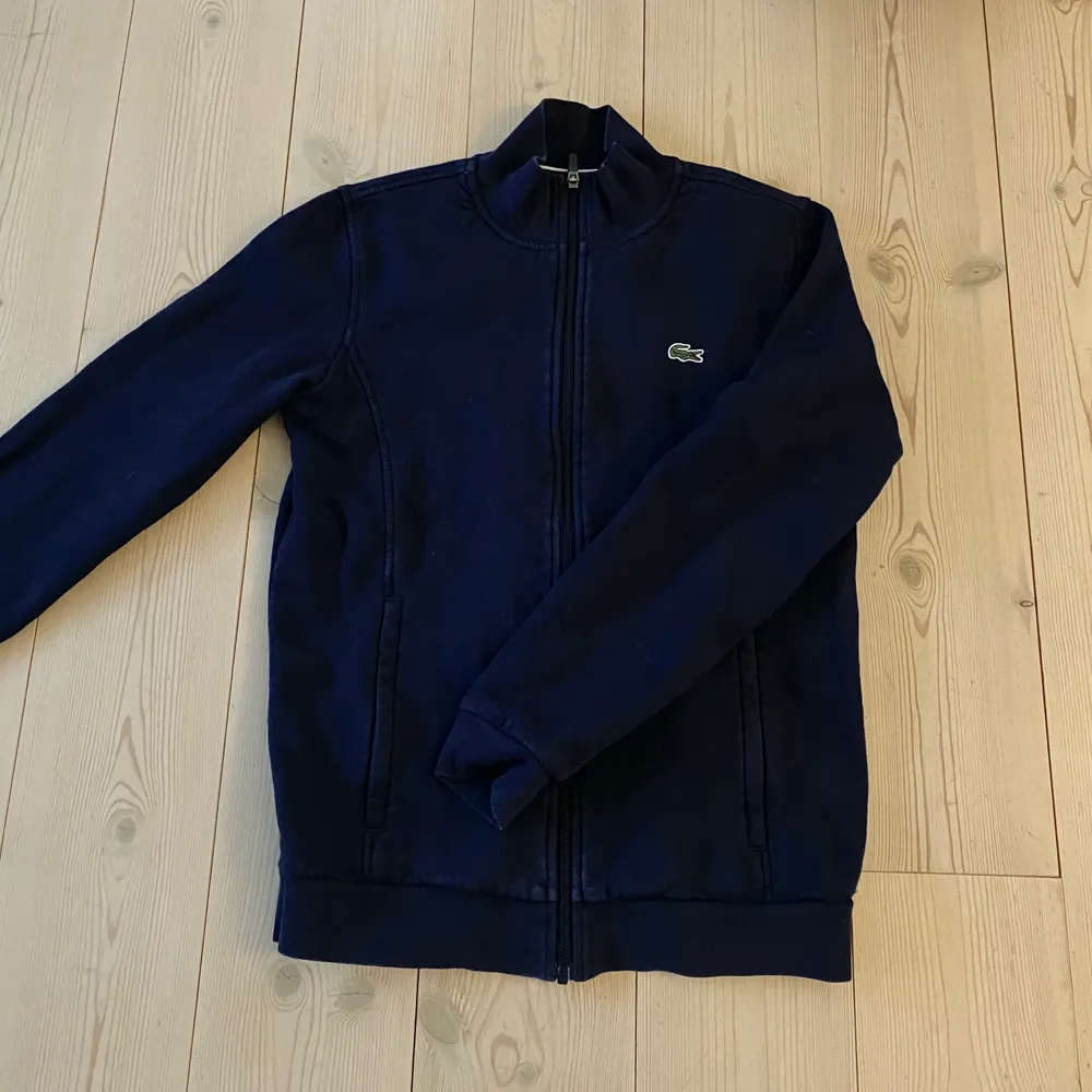 Superfin mörkblå ”zip hoodie” (fast utan luva) från Lacoste. Bra skick!. Tröjor & Koftor.