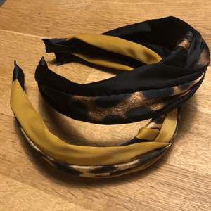 Två hårband som inte kommer till användning, en svart med guldiga detaljer, och en guldig med svarta detaljer. Kan säljas separat, frakt ingår