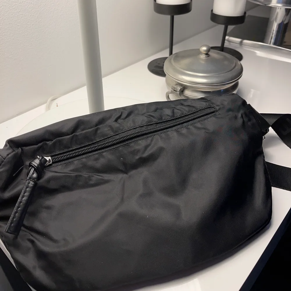 Jättefin svart crossbody väska från DAY. Använd ett fåtal gånger men fortfarande i fin skick! Den kan både användas runt kroppen som på bilden men även runt midjan! . Väskor.