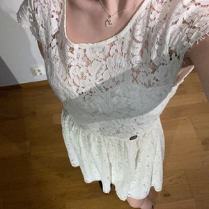 Studentklänning - Superfin vit klänning i spets, använd 1 gång. Helt perfekt studentklänning med en fin öppen rygg! Storlek 42 (lite liten i storleken) säljer för 200 kr plus frakt