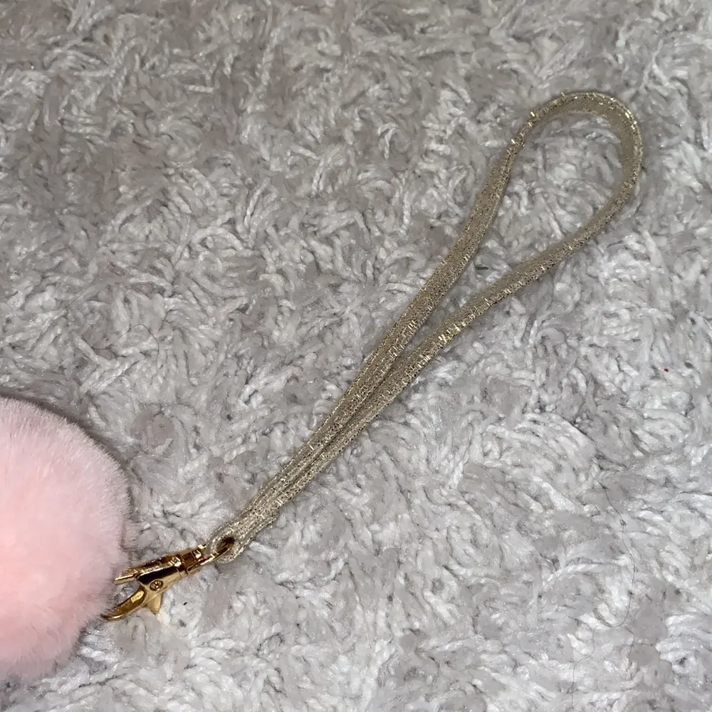 En glittrig guld nyckelband med en rosa pompom.💕 Perfekt till bilnyckeln.🚙 Säljer eftersom jag fick en ny i julklapp💓 Betalning via swish, endast seriösa köpare, tack❤️. Accessoarer.